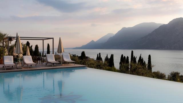 Infinity-Pool mit Terasse vor mediteraner Bergsee-Kulisse